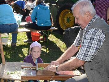 Antonia Fröba holt von Klaus Glatzer den in Scheiben gehobelten Weißkohl als Nachschub zum Einstampfen in die Fässer.