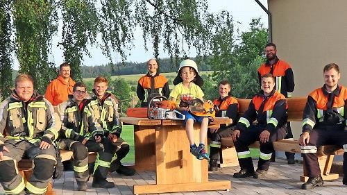 Die Jungfeuerwehrler aus Schönderling sind stolz auf ihre neue Sitzbank (sitzend von links): Max Wießner, Niklas Müller, Dominik Schäfer, Max Kliem (auf dem Tisch), Fabian Brust, Moritz Karges, Julian Brand, (dahinter stehend) 2. Kommandant Siegbert Müller und 1. Kommandant Beck Christian, Feuerwehrmann Philipp Bausch.