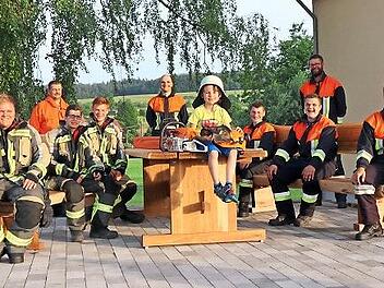 Die Jungfeuerwehrler aus Schönderling sind stolz auf ihre neue Sitzbank (sitzend von links): Max Wießner, Niklas Müller, Dominik Schäfer, Max Kliem (auf dem Tisch), Fabian Brust, Moritz Karges, Julian Brand, (dahinter stehend) 2. Kommandant Siegbert Müller und 1. Kommandant Beck Christian, Feuerwehrmann Philipp Bausch.