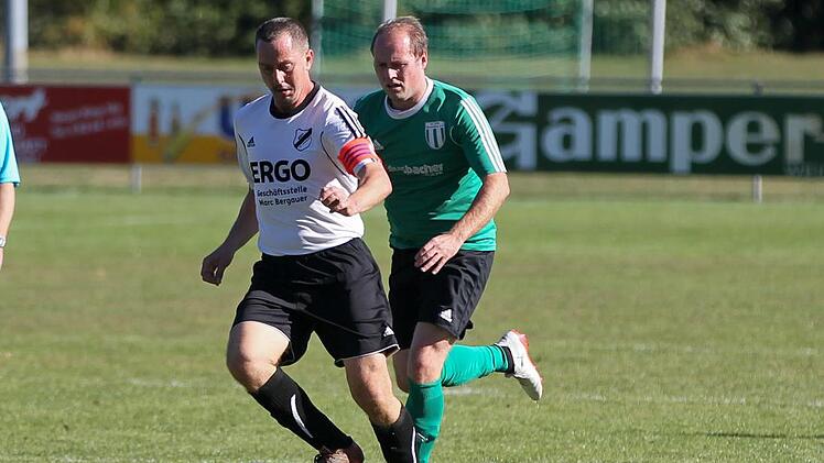 Läuft der Konkurrenz davon: Kapitän Alexander Weimer vom SSV Ober-/Unterlangenstadt (weißes Trikot) führt den Ball vor Sebastian Adelbert vom SC Hassenberg.  Foto: Heinrich Weiß