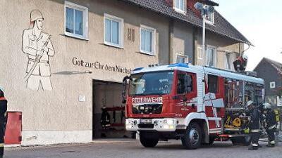 Das L&ouml;schfahrzeug der Feuerwehr Mitwitz mit Einsatzkr&auml;ften im L&ouml;scheinsatz und Kr&auml;ften, die den Leitereinsatz vorbereiten Foto: Matthias Schuhb&auml;ck