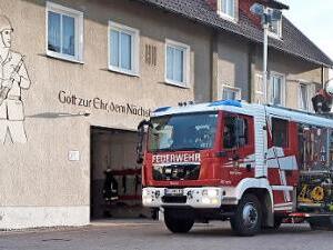 Das Löschfahrzeug der Feuerwehr Mitwitz mit Einsatzkräften im Löscheinsatz und Kräften, die den Leitereinsatz vorbereiten Foto: Matthias Schuhbäck