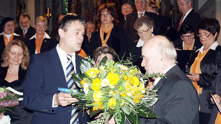 Nach den Blumen der Chorgemeinschaft überreicht Bürgermeister Gerhard Wunder (li) im Namen des Landkreises ein Geschenk an Walter Klose.