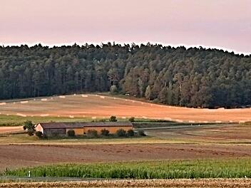 Auf der gelbbraunen Fläche im Hintergrund, entlang des Waldrandes, soll der Solarpark "Dürrenried II" entstehen, der in dem Dorf für Aufregung sorgt.Helmut Will