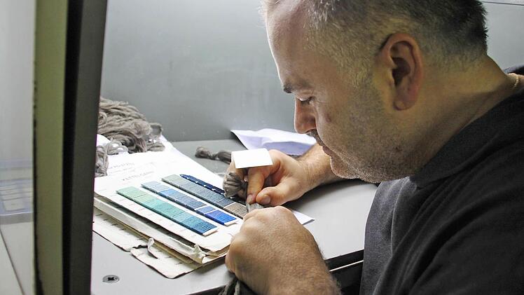 Ein Mitarbeiter vergleicht die Farben der Fäden, die der Kunde bestellt hat - im Laufe der Jahre hat sich die Farbe leicht verändert.  Fotos: Sarah Stieranka