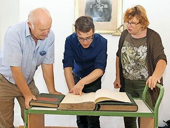 Handgeschrieben, sauber und ordentlich: Heinz Stammberger, Johannes Haslauer und Ursula Stammberger sind fasziniert von den spannenden Informationen, die den alten Stöppacher Flurbüchern zu entnehmen sind. Foto: Michael Stelzner