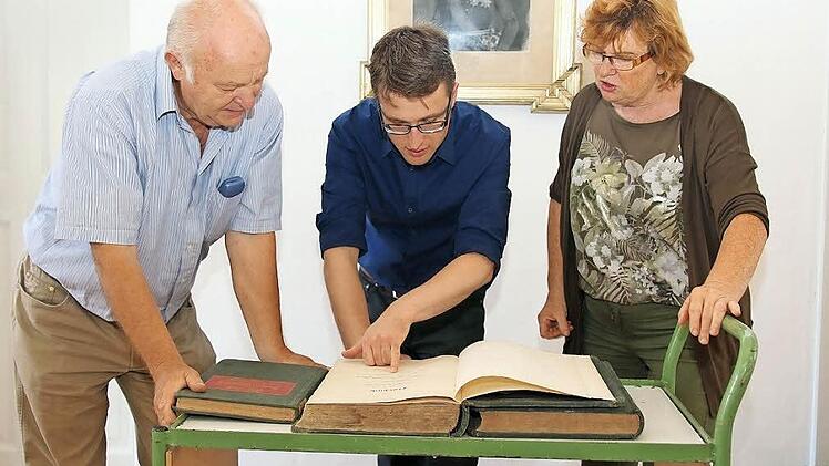 Handgeschrieben, sauber und ordentlich: Heinz Stammberger, Johannes Haslauer und Ursula Stammberger sind fasziniert von den spannenden Informationen, die den alten Stöppacher Flurbüchern zu entnehmen sind. Foto: Michael Stelzner