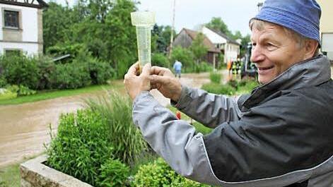 31 Liter auf dem Quadratmeter haben in Salmsdorf die Hauptstraße unter Wasser gesetzt, wie Ludwig Bock zeigt. Foto: Ralf Kestel
