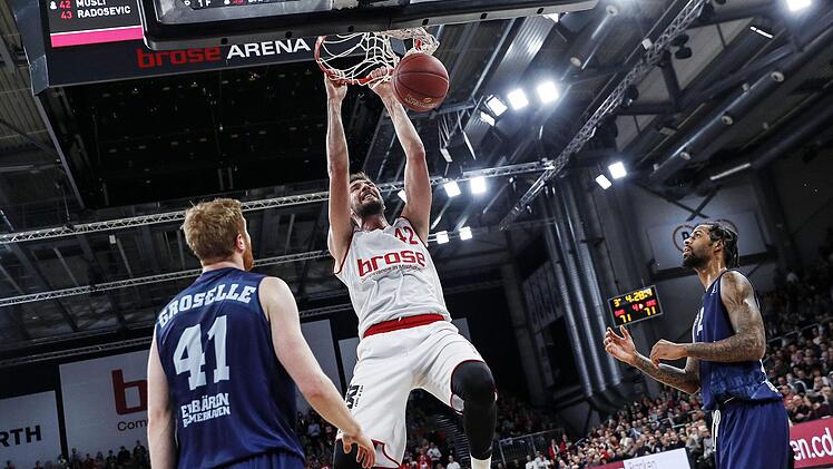 Dejan Musli schließt am 11. Dezember gegen den Eisbären-Center Geoffrey Groselle (l.) per Dunking ab. Mit 14 Punkten und elf Rebounds hatte der Neuzugang maßgeblichen Anteil am Brose-Erfolg. Foto: Daniel Löb