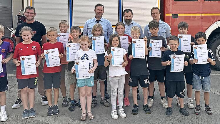 Stolz präsentieren die „Feuerdrachen“ Urkunden und Abzeichen. Mit ihnen freuen sich (hinten, von links) Ausbilder Martin Menrath, David Sarid&#382;i&#263;, der Vorsitzende der Freiwilligen Feuerwehr Zapfendorf, sowie die Prüfer Holger Porzner und ...