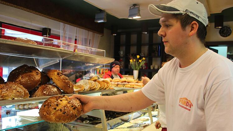 Sebastian Zipfel legt die Osterbrote in die Verkaufstheke.