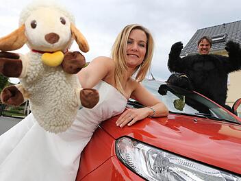 Drei erfolgreich erledigte Aufgaben in einem Foto: Im Gorillakostüm, Hochzeitskleid und mit einer Schafherde - dafür stellvertretend die Handpuppe - waren Maren und Torsten Lang schon unterwegs. Fotos: Matthias Hoch