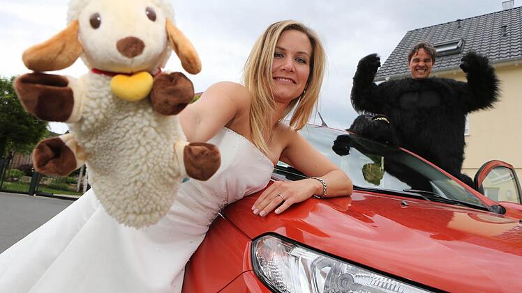 Drei erfolgreich erledigte Aufgaben in einem Foto: Im Gorillakostüm, Hochzeitskleid und mit einer Schafherde - dafür stellvertretend die Handpuppe - waren Maren und Torsten Lang schon unterwegs. Fotos: Matthias Hoch