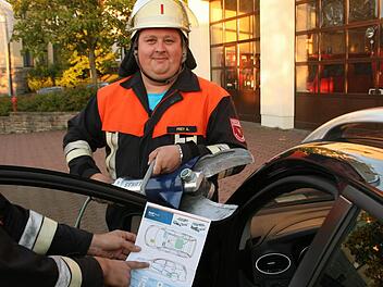 Anhand einer Auto-Rettungskarte können Alexander Frey (rechts), Kommandant der Feuerwehr Nüdlingen, und sein Stellvertreter Florian Wilm (links) schnell entscheiden, wo sie am besten die Rettungsschere ansetzen müssen. Foto: Paul Ziegler