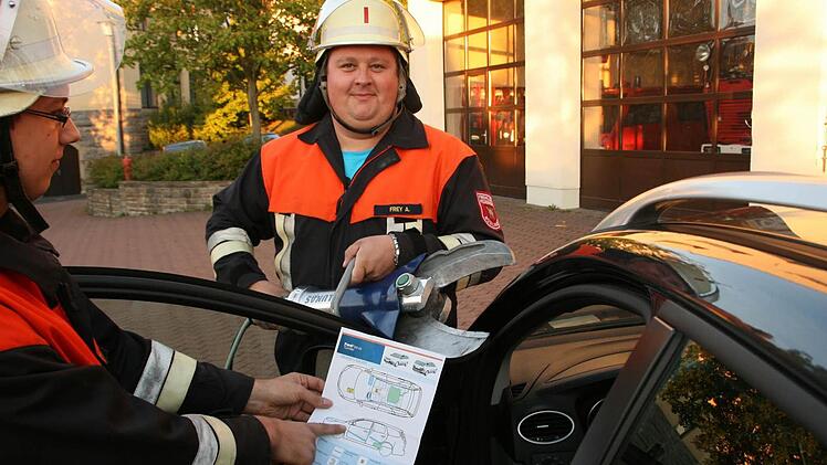 Anhand einer Auto-Rettungskarte können Alexander Frey (rechts), Kommandant der Feuerwehr Nüdlingen, und sein Stellvertreter Florian Wilm (links) schnell entscheiden, wo sie am besten die Rettungsschere ansetzen müssen. Foto: Paul Ziegler