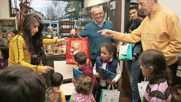 Lubna Al Hosari, Günter Brehm und Wolfgang Kümmeth (stehend von links) verteilen Geschenke, die Höchstadter Geschäftsleute spendiert hatten.  Fotos: Evi Seeger