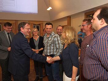 Otto Waldmann vom Amt für ländliche Entwicklung verpflichtet nach der Wahl die Vorstandsmitglieder der Teilnehmergemeinschaft einzeln per Handschlag. Foto: Arkadius Guzy