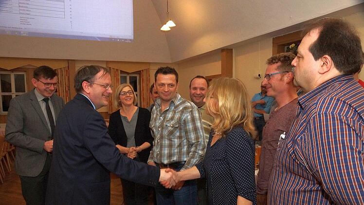 Otto Waldmann vom Amt für ländliche Entwicklung verpflichtet nach der Wahl die Vorstandsmitglieder der Teilnehmergemeinschaft einzeln per Handschlag. Foto: Arkadius Guzy