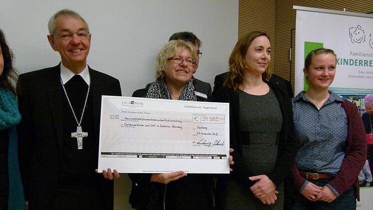 Erzbischof Ludwig Schick bei der symbolischen Scheckübergabe an Vertreter der Caritas-Beratungsstellen, die die Anträge an die Familienstiftung stellen Foto: Marion Krüger-Hundrup