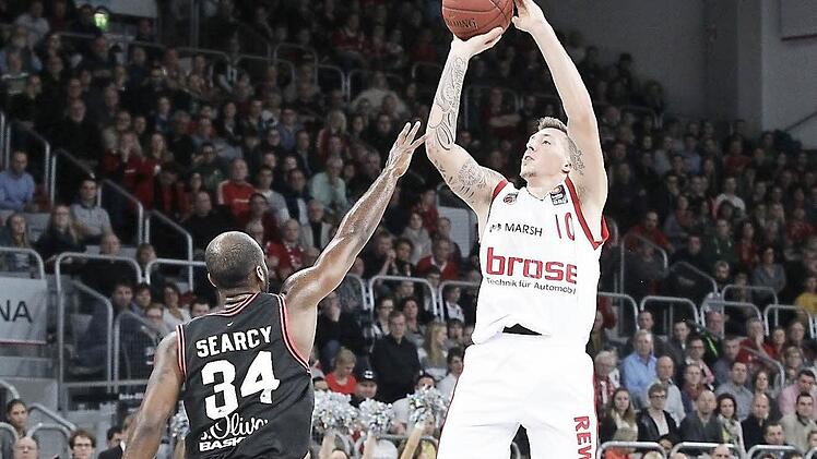 Daniel Theis lässt es nicht nur unter dem Korb krachen, er hat auch ein lockeres Händchen. Hier wirft er aus der Halbdistanz über den Würzburger Devin Searcy hinweg. Foto: sportpress