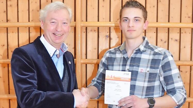 Harald Kaiser (links) überreicht an Leon Simon aus Kronach die Urkunde und das Deutsche Sportabzeichen des DOSB in Gold.  Foto: K.- H. Hofmann