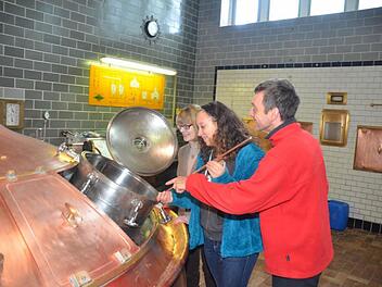 Louisa Kern (Mitte) entnimmt aus dem Braukessel (Sudpfanne) eine Probe, um die Stammwürze festzustellen. Dabei wird sie beraten von Geschäftsführerin Anette Höfner und Braumeister Oliver Kaufmann. Foto: K.- H. Hofmann
