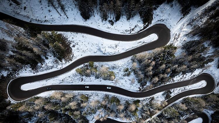 Reise, Winterreifen - Aerial view of a car serpentine on a mountain . Road to La Thuile village and ski area . Snowy mountain serpentine in Aosta valley in Italy .