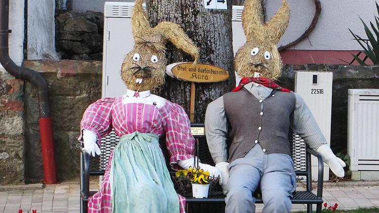 Mit Schmunzeln versuchte der Obst- und Gartenbauverein Aura das schon zweite "corona-verhagelte" Osterfest aufzuhellen. So nahm ein Osterhasen-Paar auf der neuen, von Leo Fell gefertigten und gestifteten Bank am "Hallas" Platz. Foto: Winfried Ehling