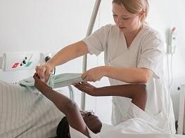 Eine Pflegekraft kümmert sich um einen Patienten.