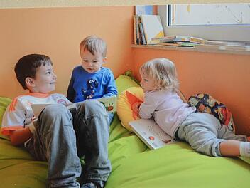 Liam (links) ist schon in der Regelgruppe und zeigt den Kleinsten Nico und Jasmin ein Bilderbuch. So lernen die Kleinen von den Großen wie es das Konzept vorsieht.  Foto: Karl-Heinz Hofmann