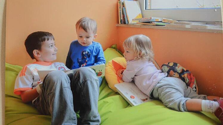 Liam (links) ist schon in der Regelgruppe und zeigt den Kleinsten Nico und Jasmin ein Bilderbuch. So lernen die Kleinen von den Großen wie es das Konzept vorsieht.  Foto: Karl-Heinz Hofmann