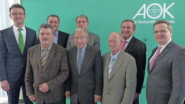 Direktor Christian Grebner (l.) und der stellvertretende Vorstandsvorsitzende Hubertus R&auml;de (r.) verabschieden die Beir&auml;te (1. Reihe v.&nbsp;l.) Richard Rauh, Matthias Fr&ouml;ba, Knut vom Berg, (2. Reihe v.&nbsp;l.) Wilhelm Tetzlaff, Dieter Saalfrank und Franz Brosch. Foto: AOK