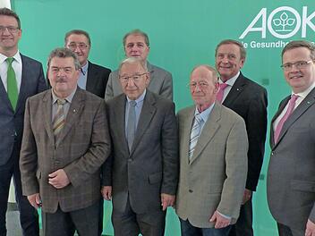 Direktor Christian Grebner (l.) und der stellvertretende Vorstandsvorsitzende Hubertus Räde (r.) verabschieden die Beiräte (1. Reihe v. l.) Richard Rauh, Matthias Fröba, Knut vom Berg, (2. Reihe v. l.) Wilhelm Tetzlaff, Dieter Saalfrank und Franz Brosch. Foto: AOK