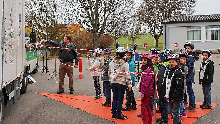 Den toten Winkel, den der Fahrer eines kleineren Lastwagens nicht einsehen kann, markiert diese orangene Fläche. Eine ganze Schulklasse hat auf ihr Platz, wie Polizeihauptmeister Matthias Kleren beim Verkehrsunterricht in Poppenlauer demonstrierte.  Foto: Dieter Britz