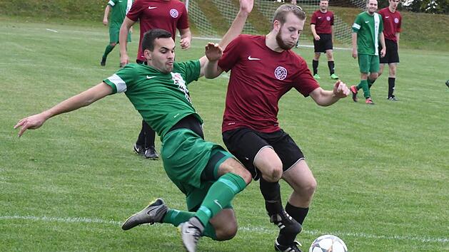 Muss sich am Ende gegen David Hahns (links) beherztes Eingreifen geschlagen geben: Maxi Wehner vom BSC Lauter verliert mit 1:2 gegen den FSV Sch&ouml;nderling. Foto: Hopf
