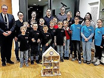 Unser Foto zeigt (von links) Bürgermeister Jochen Weber, zahlreiche Vertreter der Kinderfeuerwehr Michelau, Schwürbitz und Neuensee mit einigen Eltern und das Rauchhaus.
