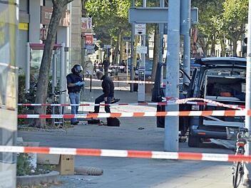 Zwei Spezialisten des Landeskriminalamtes bereiten sich auf die Untersuchung der Tasche in der Telefonzelle vor. Fotos: Ronald Rinklef