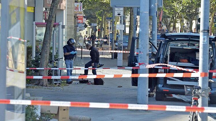 Zwei Spezialisten des Landeskriminalamtes bereiten sich auf die Untersuchung der Tasche in der Telefonzelle vor. Fotos: Ronald Rinklef