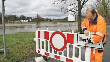 Edwin Lindner sperrt die Straße zwischen Ziegelhütte und Skaterbahn in Stadtsteinach ab: Sie ist überflutet. Foto: Sonja Adam
