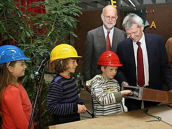 Laura, Elias und Johannes füllen die Metallhülse für den Grundstein mit den Bürgermeistern Johann Kalb, Karl-Heinz  Wagner (von links) und Architekt Christoph Gatz (hinten). Foto: Barbara Herbst
