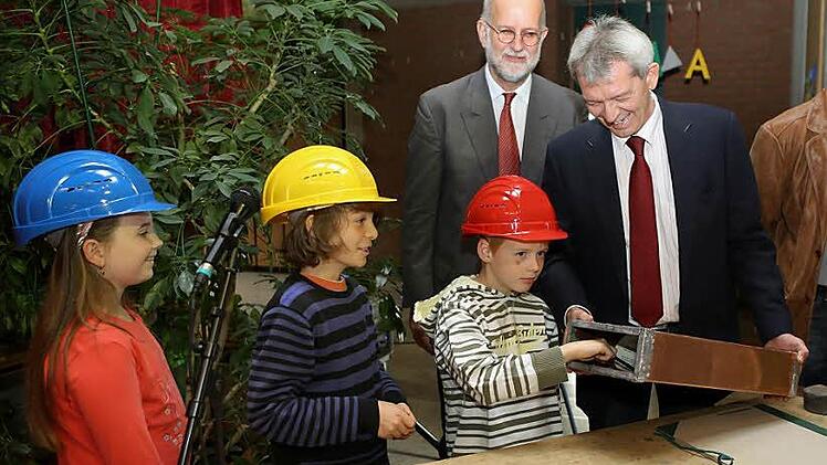 Laura, Elias und Johannes füllen die Metallhülse für den Grundstein mit den Bürgermeistern Johann Kalb, Karl-Heinz  Wagner (von links) und Architekt Christoph Gatz (hinten). Foto: Barbara Herbst