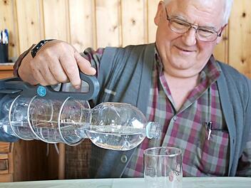 Paul Schmitt nutzt seinen Flaschenhalter täglich. Federhalterung und Henkel ermöglichen auch ein bequemes Einschenken ins Glas.  Foto: Heike Beudert
