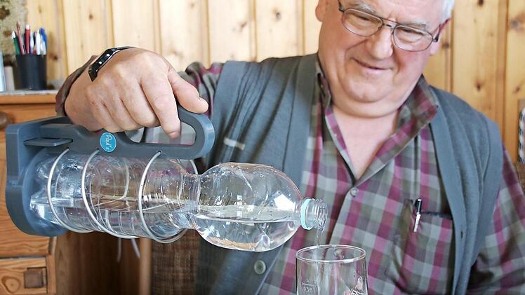 Paul Schmitt nutzt seinen Flaschenhalter täglich. Federhalterung und Henkel ermöglichen auch ein bequemes Einschenken ins Glas.  Foto: Heike Beudert
