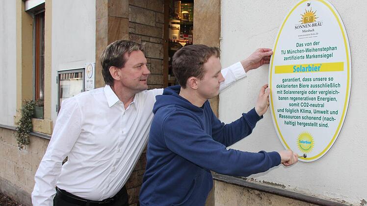 Ralf und Daniel Schmitt montieren das neue Zertifikat für ihre Brauerei neben die Eingangstür. Foto: Ralf Kestel