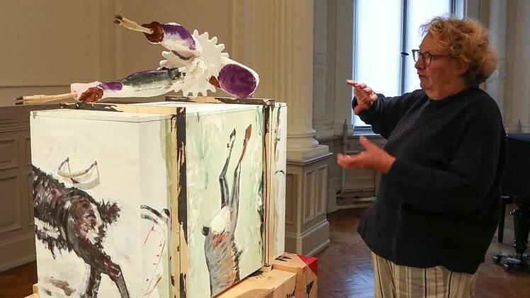 Kunstvereinsvorsitzende Barbara Kahle vor Florian Hüttners Bilderkiste, auf der ein deformierter Wildkadaver liegt.  Fotos: Barbara Herbst