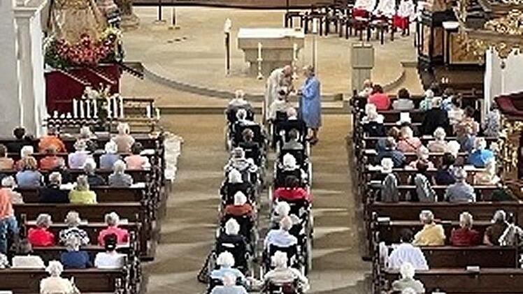 Rollstuhlfahrer, Rollatorennutzer und Fußgänger kommen zum Gottesdienst in der Oberen Pfarre.