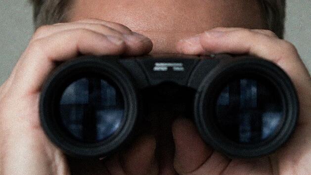 Mann schaut durch Fernglas