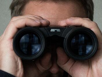 Mann schaut durch Fernglas
