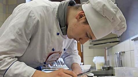 Jungkoch Konstantin Kuntzsch entgrätet ein Saiblingsfilet.