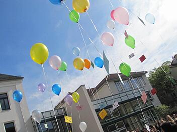 Rund 30 Luftballons mit Friedensbotschaften steigen vor dem Gymnasium Ernestinum in den Himmel. Foto: Martin Koch